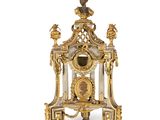 une horloge dorée et blanche surmontée d'un oiseau