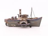 une petite maquette de bateau posée sur une surface blanche