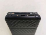 the back of a black cell phone sitting on top of a white surface