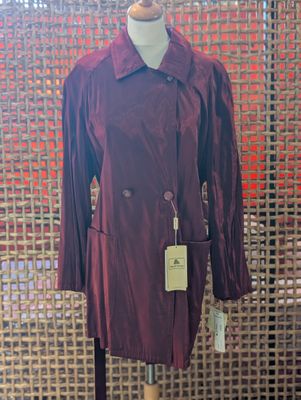 a close up of a mannequin wearing a red coat on a mannequin stand
