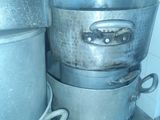 pots and pans are stacked on a metal shelf in a kitchen