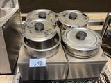 une machine sur laquelle sont posés quatre récipients métalliques