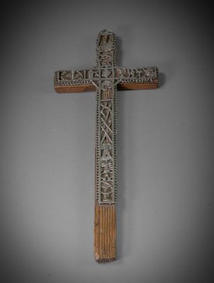 a wooden cross with carvings on it against a gray background