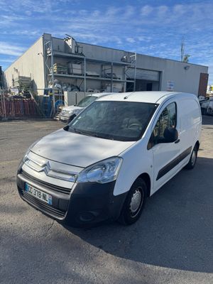 une camionnette blanche garée sur un parking à côté d'un bâtiment