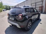 the rear end of a black car parked in a parking lot