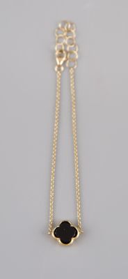 a gold necklace with a black stone on a chain