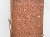 an old book sitting on top of a white table next to a white wall