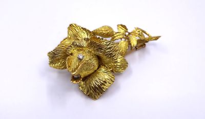 an image of a gold flower brooch on a white background