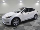 un SUV Tesla blanc garé dans un garage dont le sol est en damier