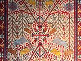 un tapis persan ancien orné d'oiseaux et de fleurs sur fond rouge