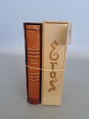 Deux livres sont posés dans une boîte en carton sur une table.