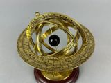 an antique brass sundial on a wooden base with a black stone