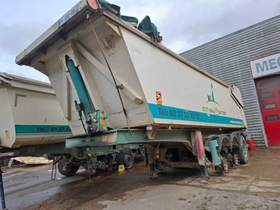 un camion-benne garé devant un immeuble