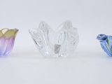 three different colored glass vases sitting next to each other on a white surface