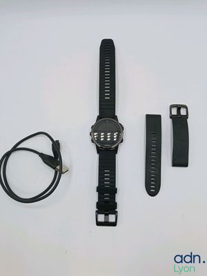 a watch that is laying on a table next to a charger