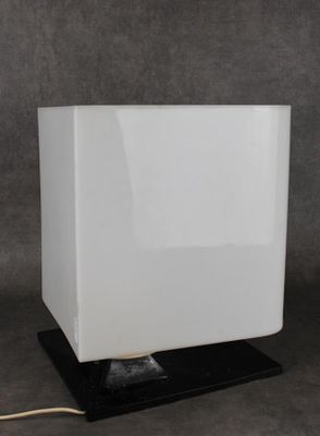 un gros plan d'une lampe posée sur une table, avec un pied noir