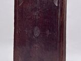 an old book sitting on top of a white table next to a white wall