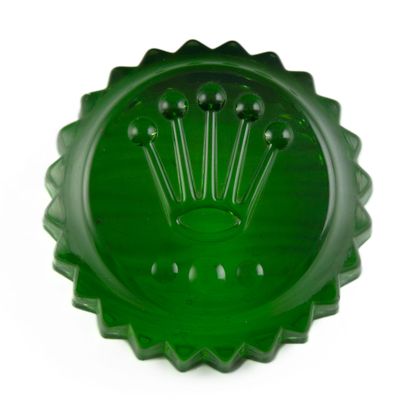 un bol en verre vert orné d'un motif en forme de couronne