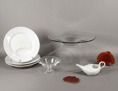 une table en verre sur laquelle sont posés une assiette, un bol, une soucoupe et une soucoupe