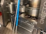 Dans une cuisine professionnelle, les casseroles et les poêles sont posées par terre.