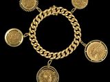 Gros plan sur un bracelet en or orné de pièces de monnaie