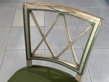 une chaise avec une assise verte posée sur un sol carrelé