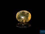 a close up of a yellow crystal ball on a black surface