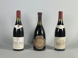 trois bouteilles de vin sont alignées sur une table
