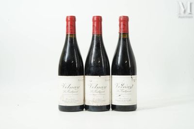 trois bouteilles de vin rouge posées sur une table blanche