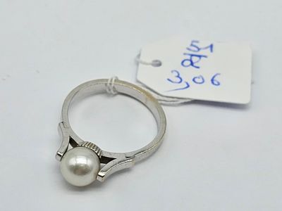 a close up of a ring with a pearl on it