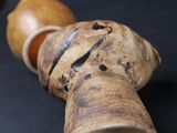 a wooden pipe with a wooden handle on a black surface