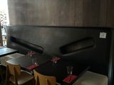 tables and chairs in a restaurant with wooden walls and a black bench