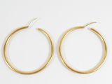 a pair of gold hoop earrings on a white background