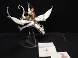 une figurine représentant un homme chevauchant un dragon, posée sur une table