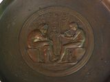 a bronze plate with a picture of a man and a woman sitting on a bench