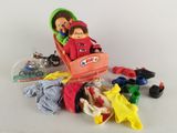 une poupée et une autre poupée dans un landau en plastique, entourées d'autres jouets