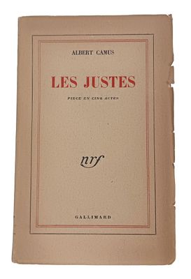 un vieux livre portant des inscriptions rouges, posé sur une surface blanche