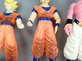 dragon ball action figures are lined up in a row on a gray surface