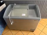 an empty freezer sitting on a tiled floor in a kitchen