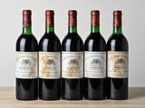 quatre bouteilles de vin sont alignées sur une table en bois