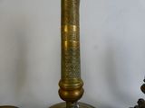 a gold colored candle that is on top of a table