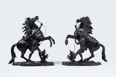 une paire de statues noires représentant un homme à cheval et une femme à cheval