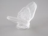 une sculpture en verre représentant un oiseau sur un fond blanc