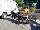 a motorcycle parked next to a van in a parking lot
