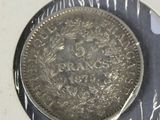 a silver coin sitting on top of a silver plate
