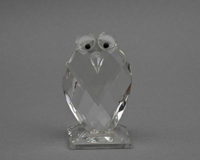figurine de chouette en cristal sur socle transparent, aux yeux noirs
