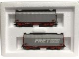 deux wagons de train miniature dans une boîte blanche posée sur une surface blanche