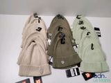 several hats are lined up on a table with tags on them