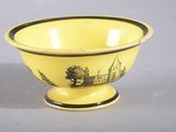 yellow and black bowl with a black design on the bottom