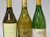 trois bouteilles de vin sont alignées sur une table
